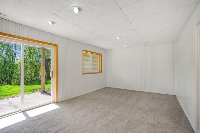 spare room featuring carpet flooring and a drop ceiling