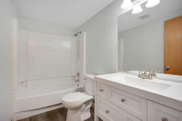 full bath featuring wood finished floors, toilet, washtub / shower combination, and vanity