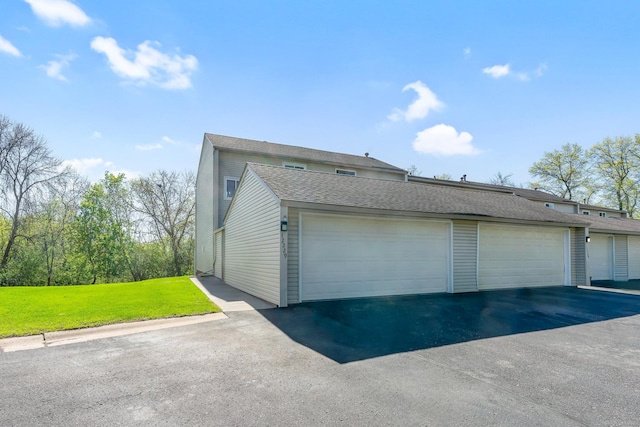 view of property exterior featuring roof with shingles and a yard