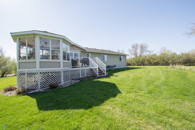 6673 230th St N, Cromwell Twp, MN 56549 - rear view of house featuring a yard and a sunroom