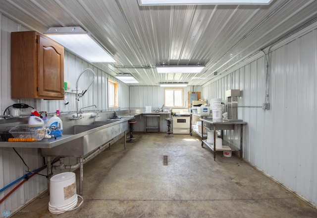 6673 230th St N, Cromwell Twp, MN 56549 - kitchen with unfinished concrete flooring, white range oven, and brown cabinets