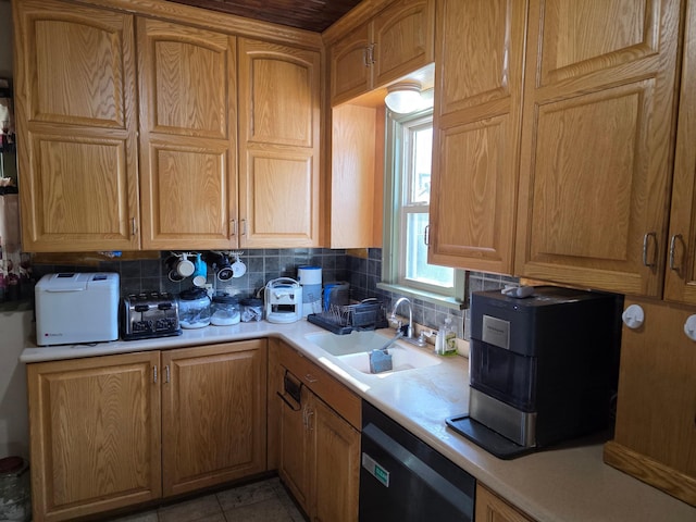 kitchen featuring dishwashing machine, a sink, light countertops, decorative backsplash, and light tile patterned floors