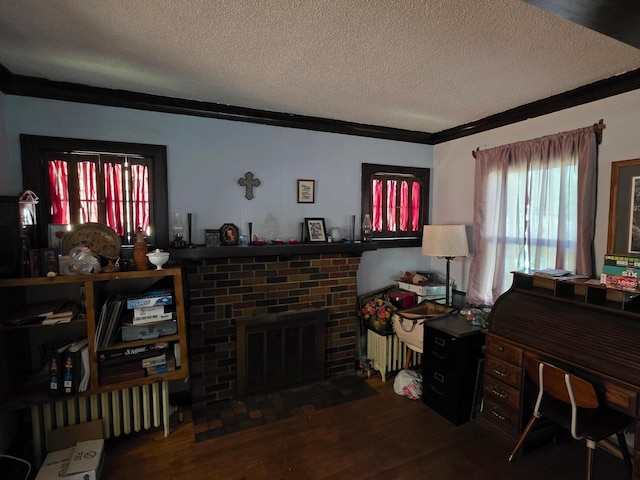 living area with crown molding, a brick fireplace, a textured ceiling, wood finished floors, and radiator heating unit