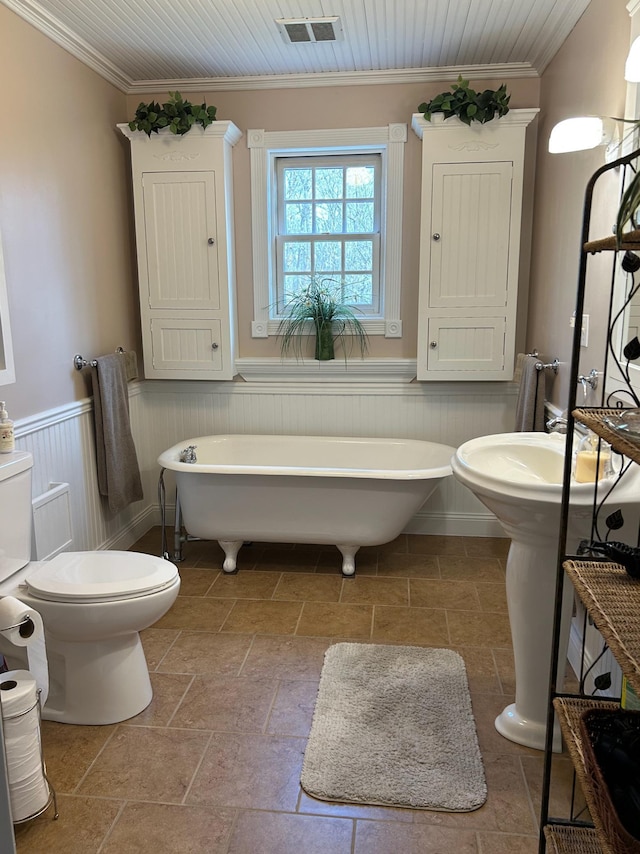 12176 2nd St, Northome, MN 56661 - full bath with a soaking tub, crown molding, a wainscoted wall, and stone tile flooring