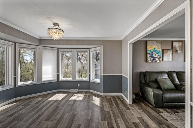 10409 Goldenrod St NW, Coon Rapids, MN 55448 - unfurnished living room featuring dark wood-style flooring, a chandelier, baseboards, and crown molding