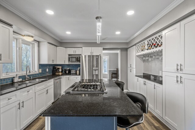 10409 Goldenrod St NW, Coon Rapids, MN 55448 - kitchen featuring appliances with stainless steel finishes, a sink, a breakfast bar area, healthy amount of natural light, and recessed lighting