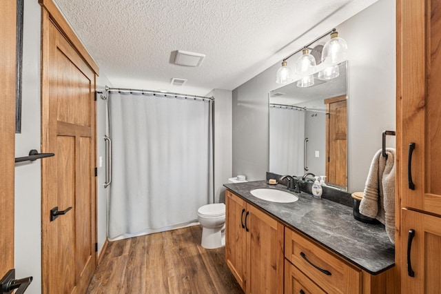49935 Acacia Trl, Nessel Twp, MN 55080 - full bath featuring wood finished floors, vanity, toilet, curtained shower, and a textured ceiling