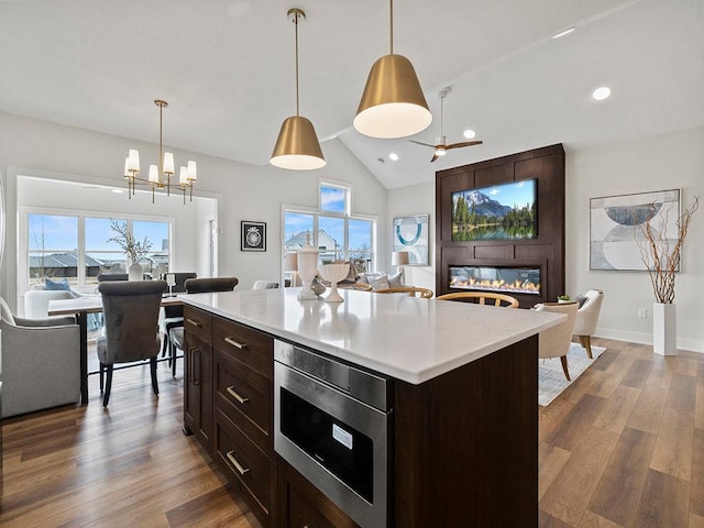 9975 Kari Way, Elko New Market, MN 55020 - kitchen with stainless steel microwave, light countertops, wood finished floors, a chandelier, and hanging light fixtures
