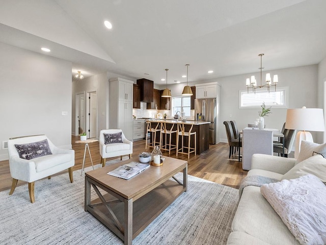 9975 Kari Way, Elko New Market, MN 55020 - living room featuring a chandelier, light wood finished floors, recessed lighting, baseboards, and lofted ceiling
