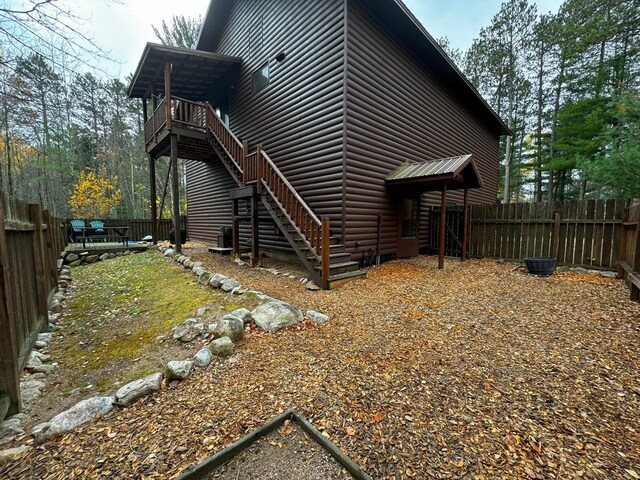 7236 Far N Rd, Buyck, MN 55771 - view of side of home featuring faux log siding, stairway, and a fenced backyard