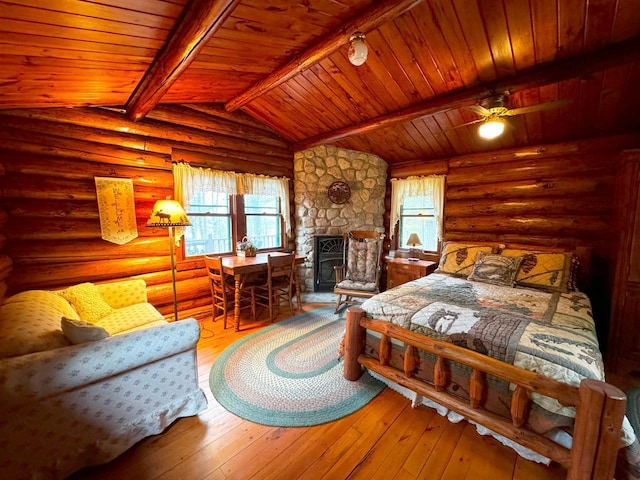 7236 Far N Rd, Buyck, MN 55771 - bedroom with wooden ceiling, rustic walls, hardwood / wood-style floors, and a stone fireplace