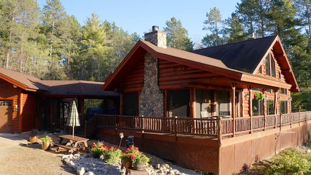 7236 Far N Rd, Buyck, MN 55771 - view of side of home featuring a chimney, log exterior, a garage, and a shingled roof