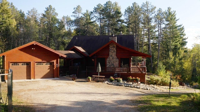 7236 Far N Rd, Buyck, MN 55771 - view of front facade with driveway, a garage, and log veneer siding