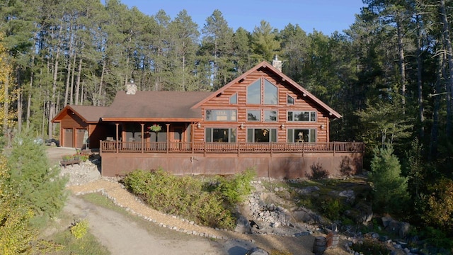 7236 Far N Rd, Buyck, MN 55771 - back of house featuring a chimney, an attached garage, a forest view, and log exterior