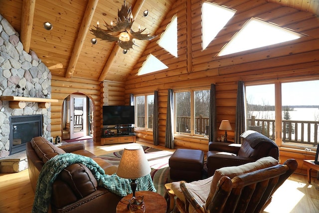 3165 Randa Rd, Orr, MN 55771 - living room featuring arched walkways, high vaulted ceiling, wood finished floors, log walls, and wood ceiling