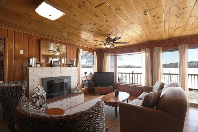 3165 Randa Rd, Orr, MN 55771 - living room with wooden walls, ceiling fan, wood ceiling, a brick fireplace, and wood finished floors