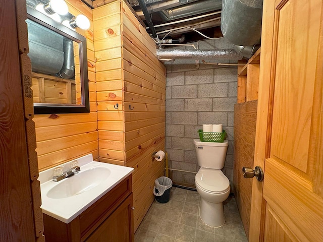 3165 Randa Rd, Orr, MN 55771 - bathroom featuring toilet, vanity, concrete block wall, and tile patterned floors