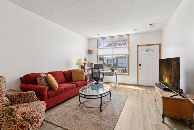 living area with a textured ceiling, wood finished floors, and baseboards
