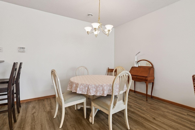 dining space featuring wood finished floors, a chandelier, and baseboards