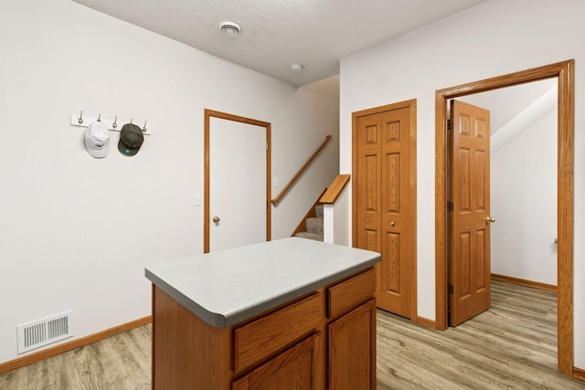 hall featuring light wood-type flooring, baseboards, and stairway