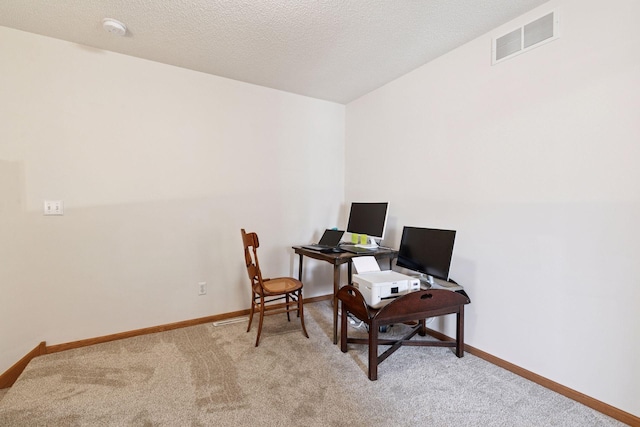 carpeted office space with baseboards and a textured ceiling
