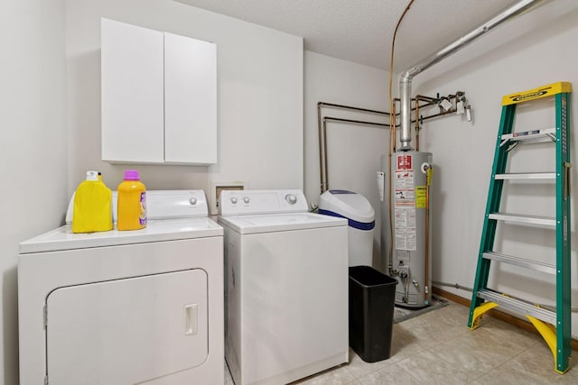 clothes washing area featuring water heater, independent washer and dryer, cabinet space, a textured ceiling, and light tile patterned floors