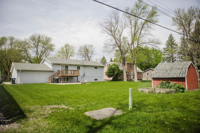view of green lawn featuring a wooden deck, an outdoor structure, a shed, and stairway