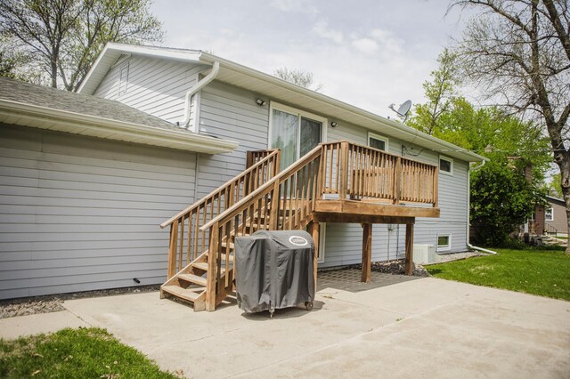 back of property featuring a patio, a deck, a yard, and roof with shingles