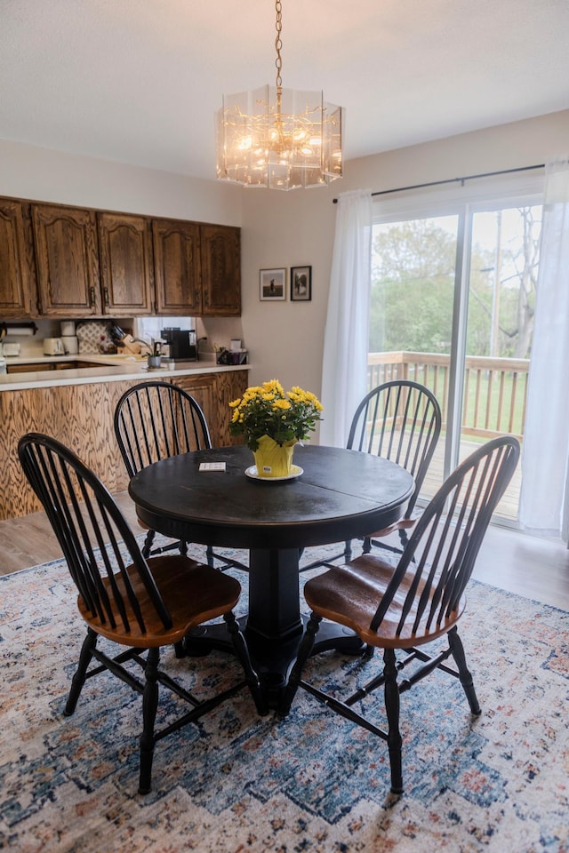 dining space with light wood finished floors and a chandelier