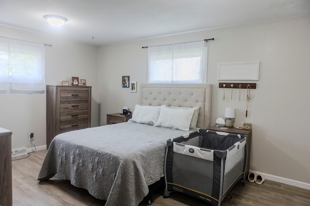 bedroom with wood finished floors and baseboards