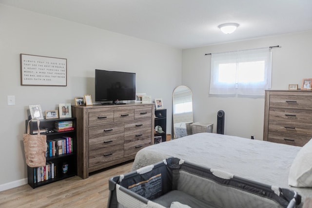 bedroom with light wood finished floors and baseboards