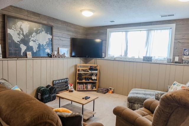 carpeted living area featuring wood walls and a textured ceiling