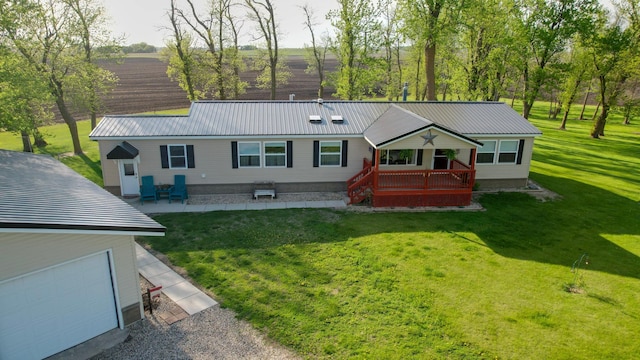 view of front of property with metal roof, a front yard, and a garage