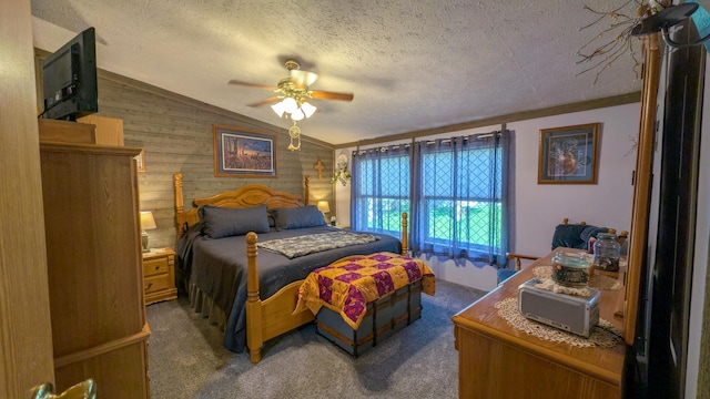 bedroom with lofted ceiling, wood walls, carpet, a textured ceiling, and ceiling fan