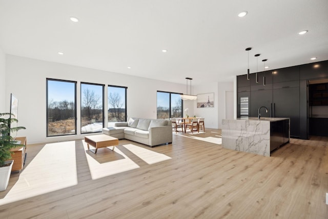 12745 Stutz Ct NE, Blaine, MN 55449 - living room with light wood-style floors, bar with sink, and recessed lighting