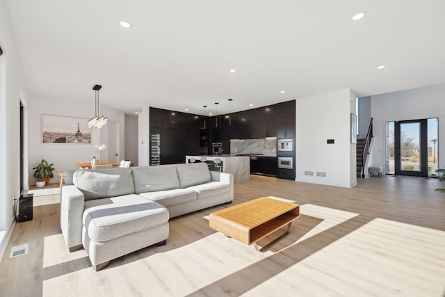 12745 Stutz Ct NE, Blaine, MN 55449 - living area with light wood-style flooring, recessed lighting, and stairway