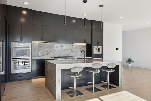 12745 Stutz Ct NE, Blaine, MN 55449 - kitchen with stainless steel double oven, modern cabinets, a sink, light wood finished floors, and recessed lighting