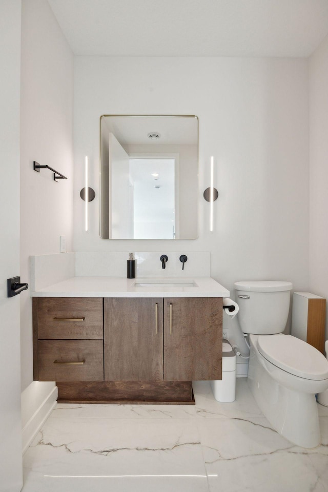 12745 Stutz Ct NE, Blaine, MN 55449 - bathroom featuring marble look tiles, toilet, and vanity