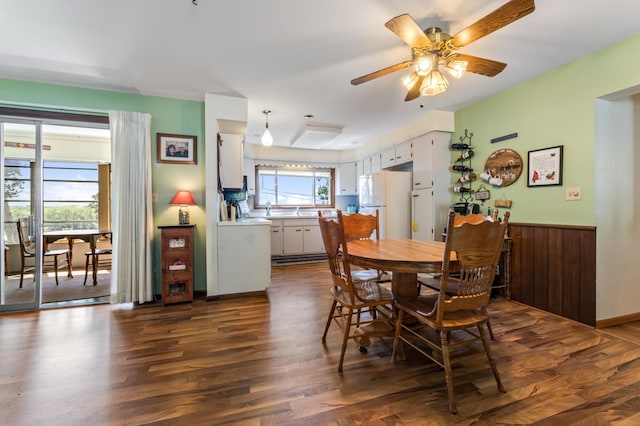 304 2nd St, Alma, WI 54610 - dining area featuring dark wood finished floors, a ceiling fan, and a wainscoted wall