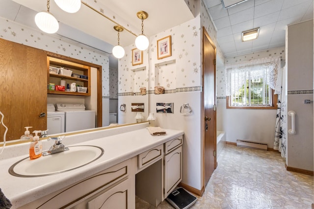 304 2nd St, Alma, WI 54610 - full bathroom with a baseboard heating unit, washer and clothes dryer, wallpapered walls, vanity, and a tub to relax in