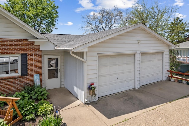 304 2nd St, Alma, WI 54610 - view of exterior entry with roof with shingles, a detached garage, and brick siding