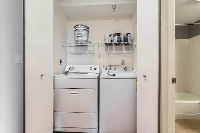 laundry room with washer and clothes dryer and tile patterned flooring