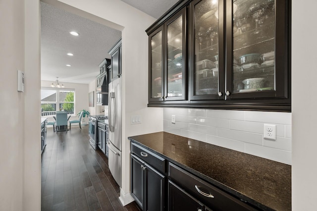4118 San Vitero Ct, Victoria, MN 55318 - bar area with dark wood finished floors, stainless steel appliances, decorative backsplash, a textured ceiling, and a chandelier