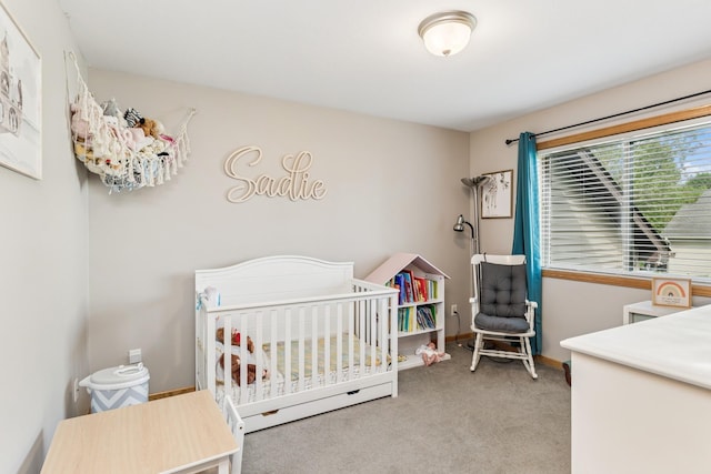 bedroom with carpet floors, a nursery area, and baseboards