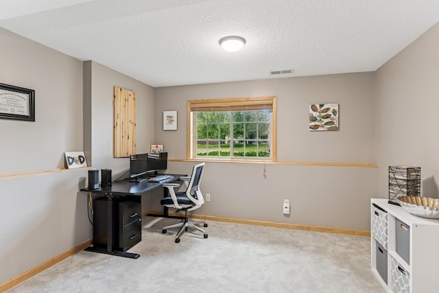office area with carpet floors, a textured ceiling, and baseboards