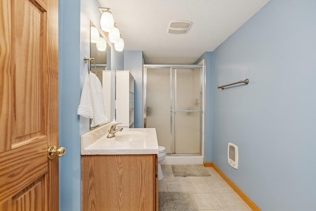 full bathroom featuring vanity, a shower stall, baseboards, tile patterned floors, and toilet