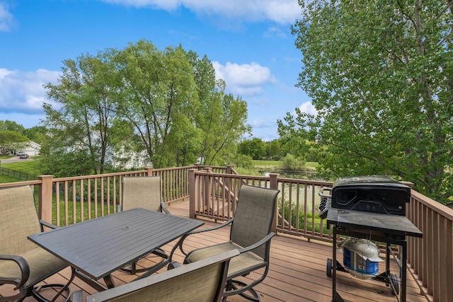 wooden deck with outdoor dining space and view of wooded area