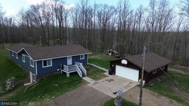791 W Rd, Wright, MN 55798 - view of front facade with an outbuilding, concrete driveway, a view of trees, and a front lawn