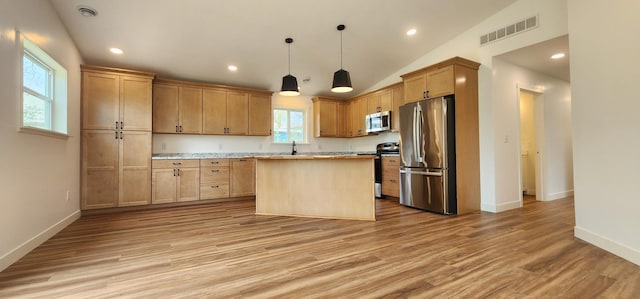 703 2nd St, Henning, MN 56551 - kitchen featuring appliances with stainless steel finishes, light wood finished floors, a center island, a sink, and baseboards