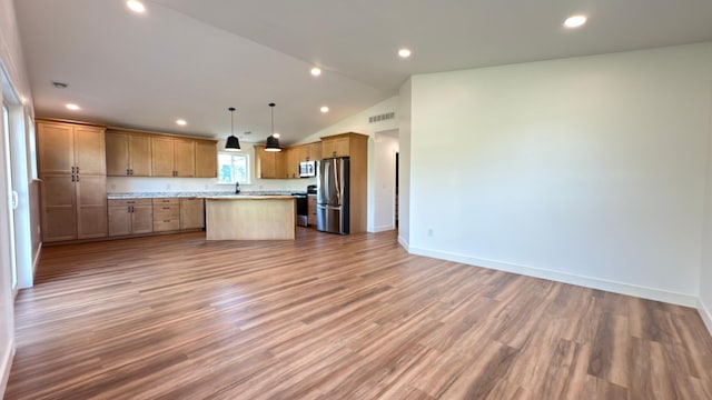 703 2nd St, Henning, MN 56551 - kitchen with stainless steel appliances, open floor plan, vaulted ceiling, baseboards, and a kitchen island